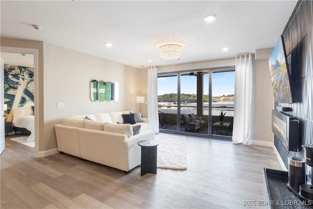 living area featuring light wood finished floors, baseboards, and recessed lighting