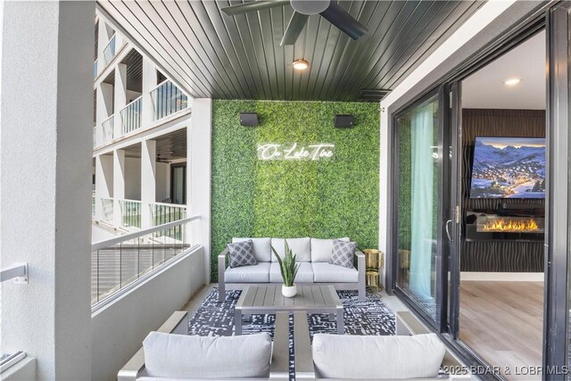 balcony with an outdoor living space and a ceiling fan