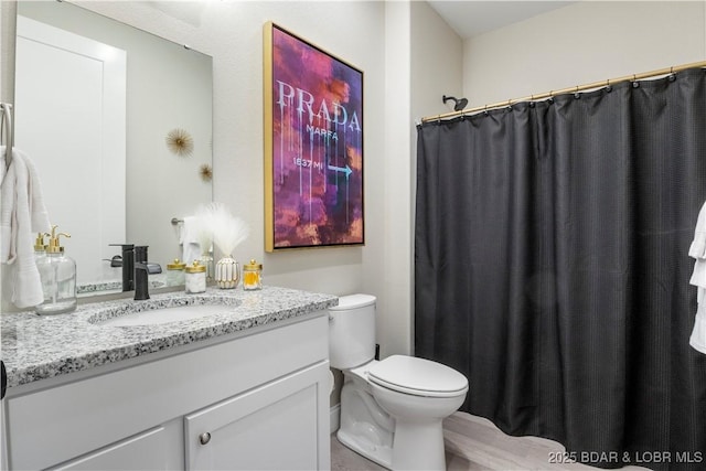 full bathroom featuring curtained shower, vanity, and toilet