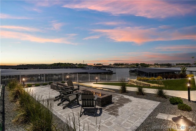 view of patio featuring a water view and fence