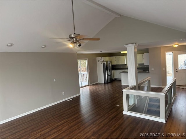 unfurnished living room featuring beam ceiling, ceiling fan, decorative columns, and dark hardwood / wood-style flooring