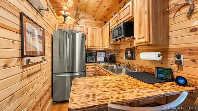 kitchen with wooden counters, stainless steel fridge, and wooden walls