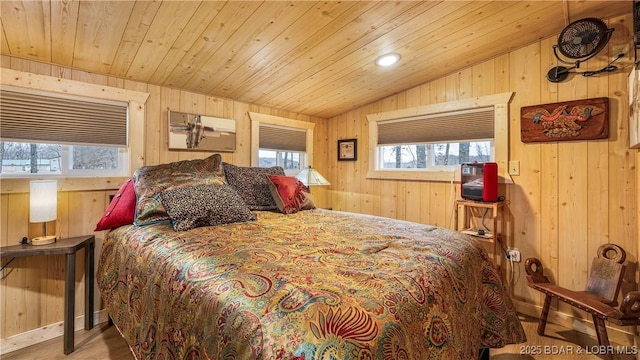 bedroom with lofted ceiling, wooden walls, and wooden ceiling