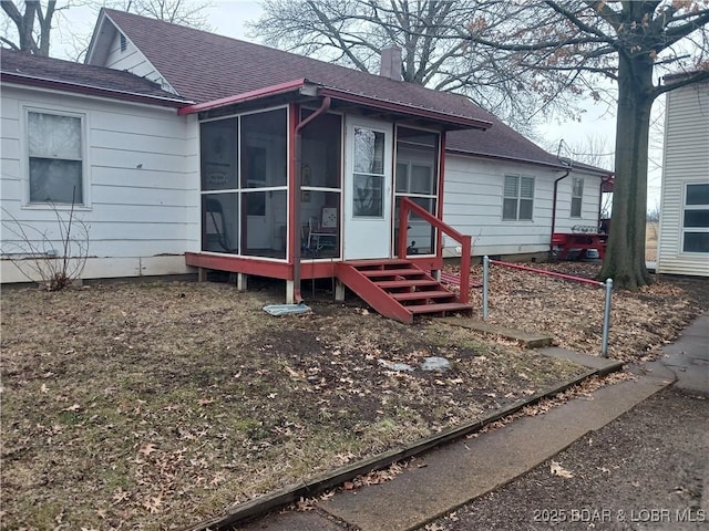 back of property with a sunroom