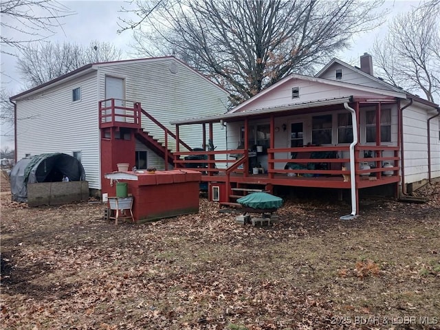 back of property featuring a sunroom and a deck