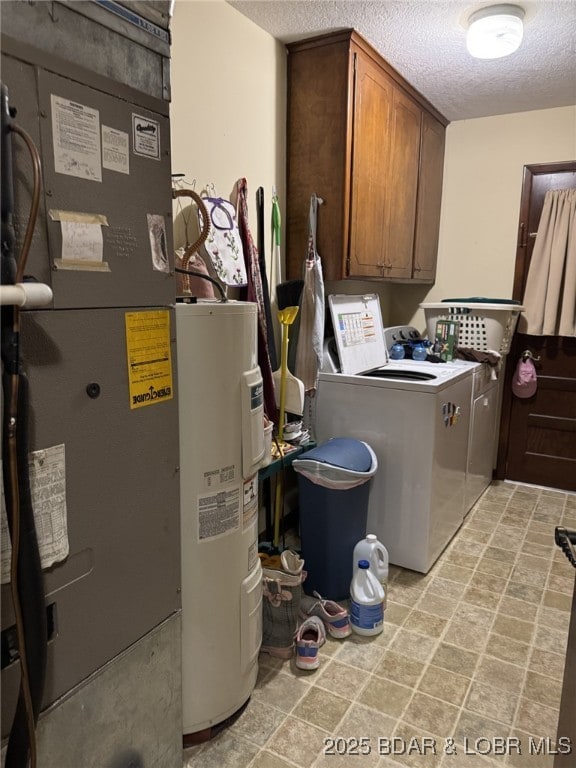 laundry room with heating unit, water heater, cabinet space, washing machine and dryer, and a textured ceiling