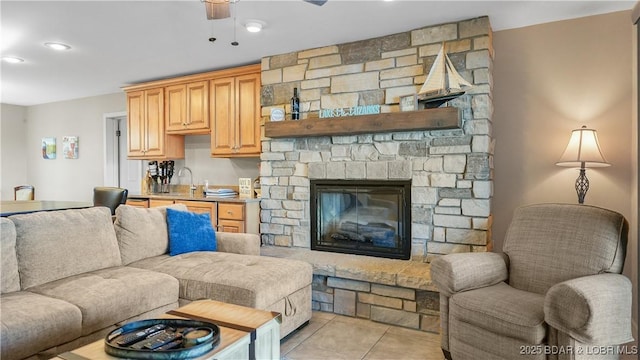 tiled living room featuring ceiling fan and a fireplace