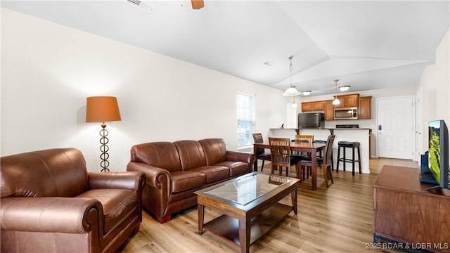 living room with lofted ceiling and light hardwood / wood-style flooring