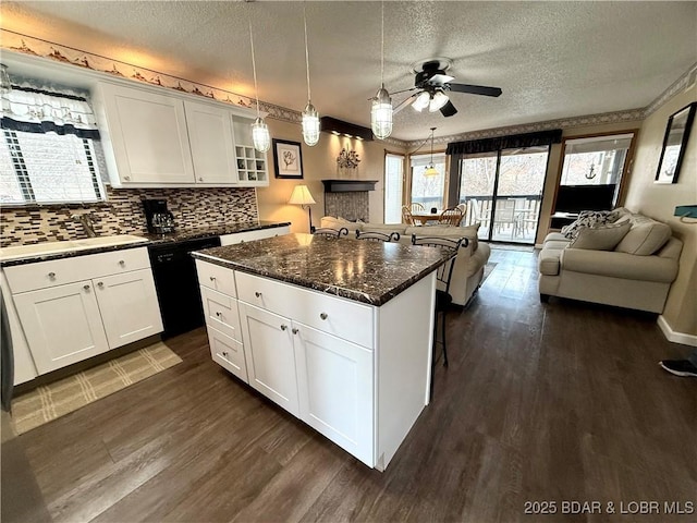 kitchen featuring a center island, dark stone counters, and white cabinets