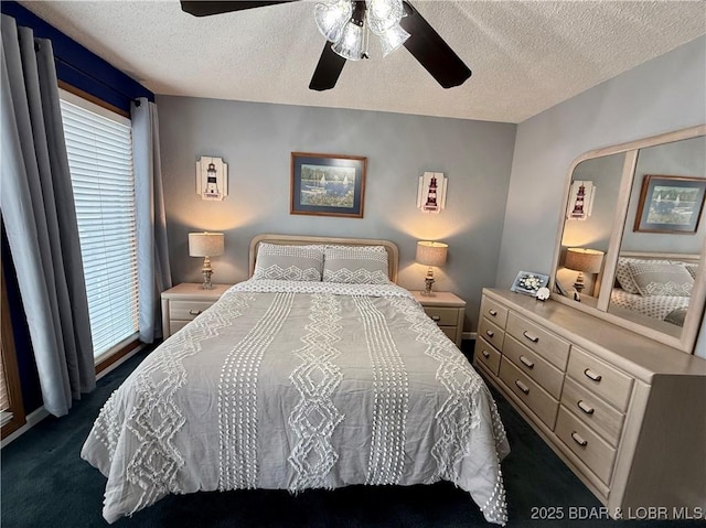 bedroom with dark carpet, ceiling fan, and a textured ceiling