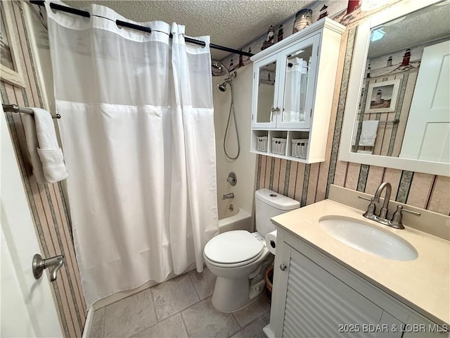 full bathroom featuring a textured ceiling, shower / bath combo with shower curtain, vanity, and toilet