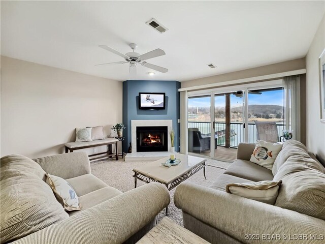 133 Cedar Glen Ct Unit 3D, Camdenton, MO 65020 - carpeted living area with a ceiling fan and a warm lit fireplace