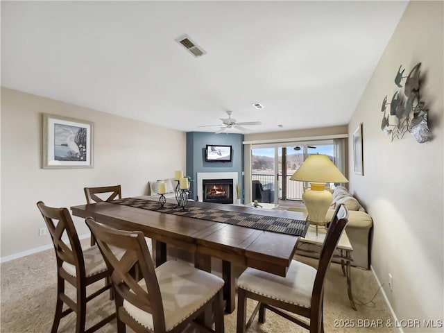 dining room featuring light carpet and ceiling fan