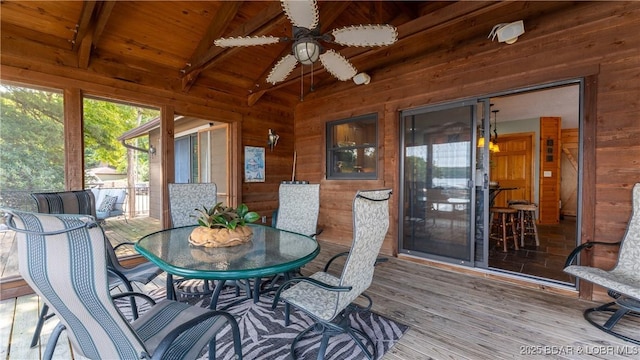 sunroom with ceiling fan, vaulted ceiling with beams, and wooden ceiling