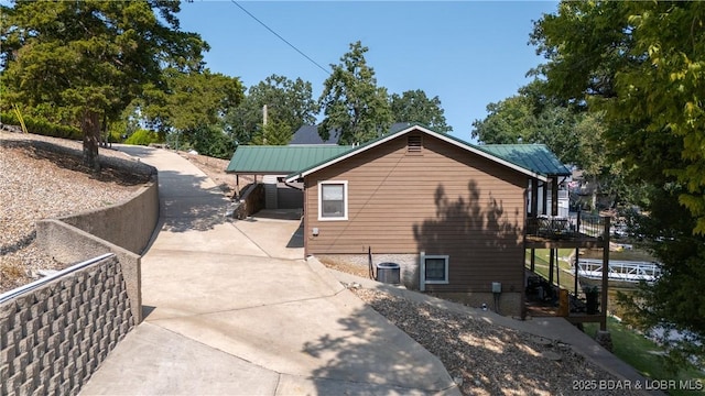 view of home's exterior with central air condition unit and a carport