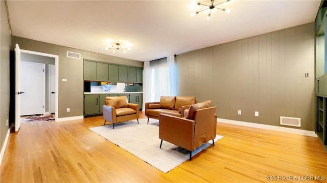 living room with an inviting chandelier and light hardwood / wood-style flooring