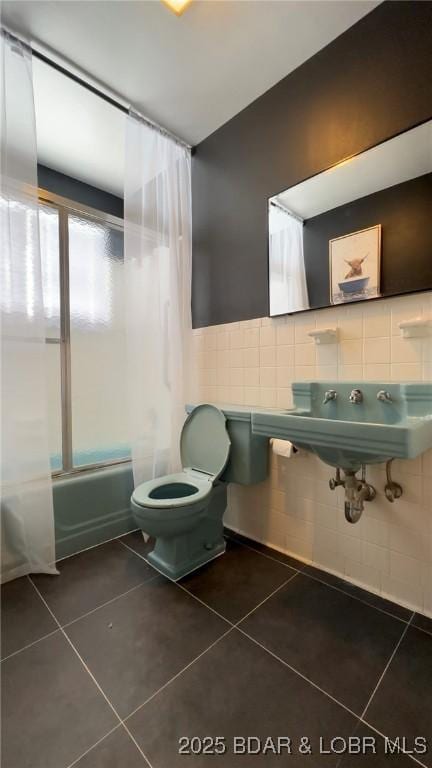 full bathroom featuring tile patterned floors, shower / bath combination, tile walls, and toilet