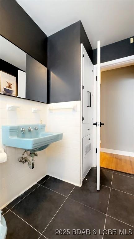 bathroom featuring tile patterned floors, tile walls, and sink