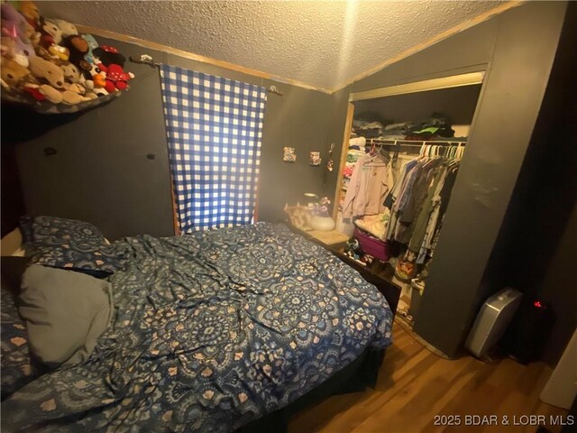 23417 Hwy Tt, Versailles, MO 65084 - bedroom with lofted ceiling, a closet, wood finished floors, and a textured ceiling