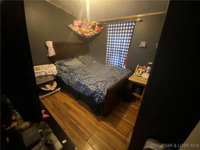 23417 Hwy Tt, Versailles, MO 65084 - bedroom with wood finished floors and a textured ceiling