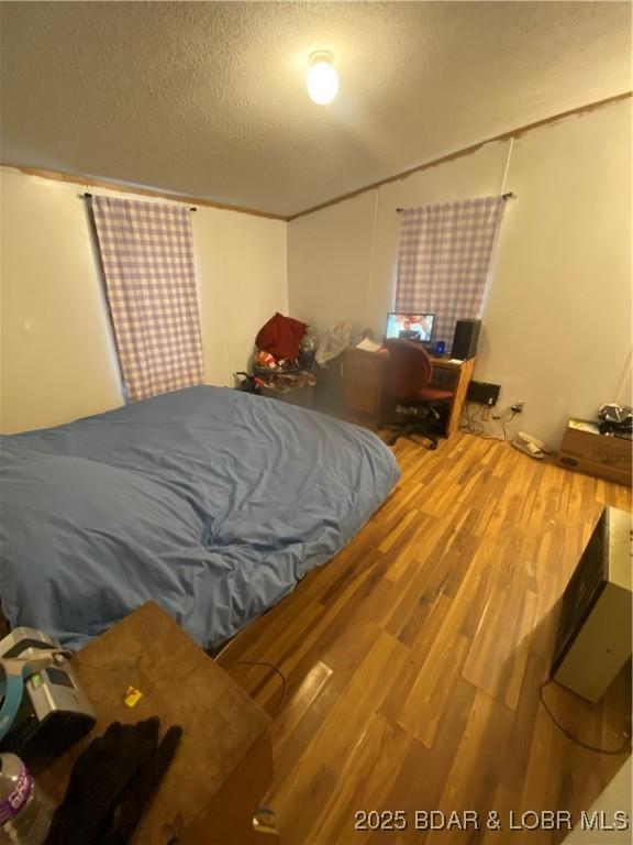 23417 Hwy Tt, Versailles, MO 65084 - bedroom with wood finished floors and a textured ceiling