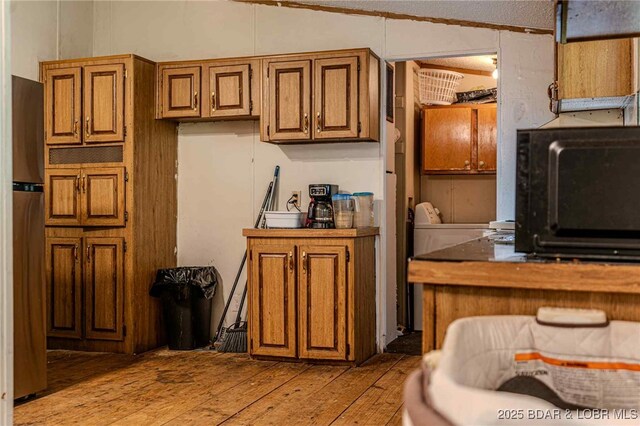 23417 Hwy Tt, Versailles, MO 65084 - kitchen with light wood-type flooring, freestanding refrigerator, lofted ceiling, and brown cabinetry