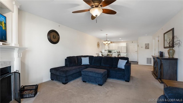 316 Cedar Heights Dr Unit 2C, Camdenton, MO 65020 - living room featuring a fireplace, a ceiling fan, light carpet, a chandelier, and baseboards