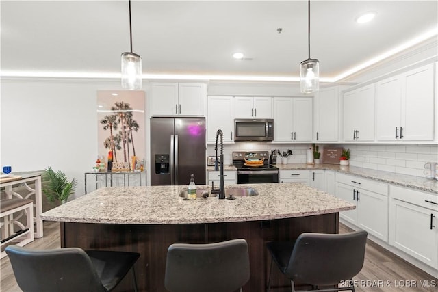 1065 Topsider Ln Unit 408, Osage Beach, MO 65065 - kitchen featuring appliances with stainless steel finishes, white cabinetry, tasteful backsplash, a sink, and ornamental molding