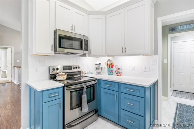 kitchen featuring appliances with stainless steel finishes, light countertops, and blue cabinets