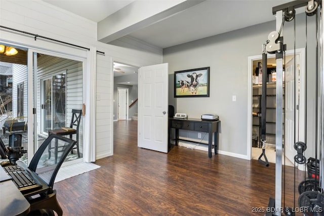 office area featuring beam ceiling, baseboards, and wood finished floors