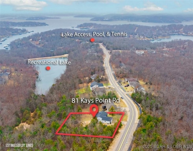 birds eye view of property with a water view and a wooded view