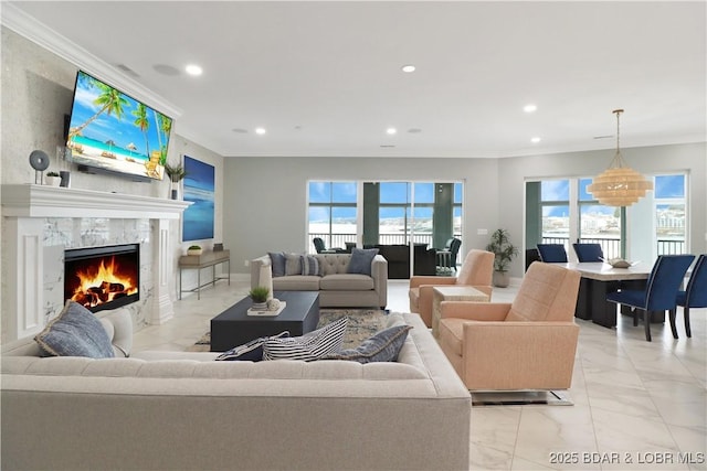 living area with marble finish floor, ornamental molding, a high end fireplace, and recessed lighting