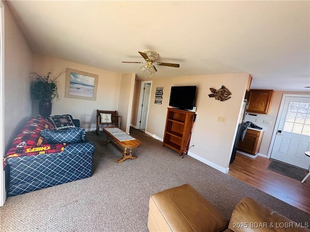 living room featuring ceiling fan, dark carpet, and baseboards