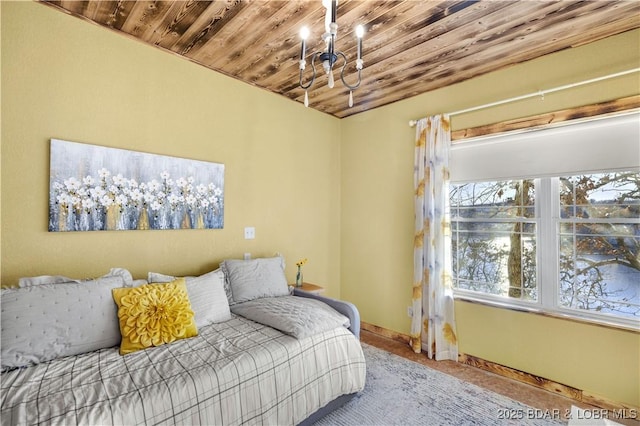 bedroom with a chandelier, wood ceiling, and baseboards