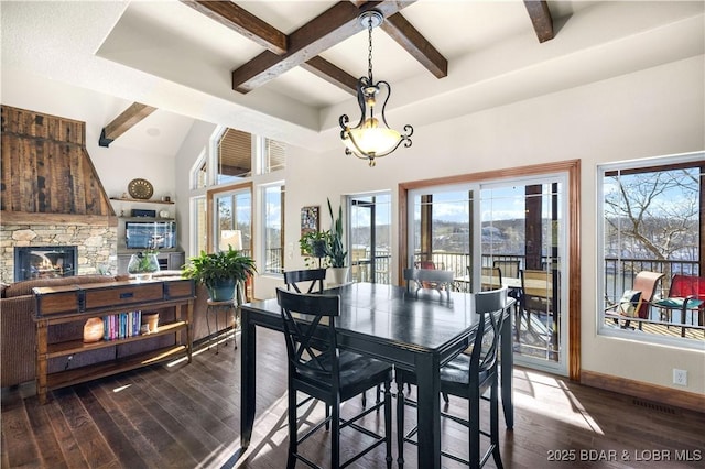 dining area featuring beamed ceiling, a fireplace, wood finished floors, and baseboards