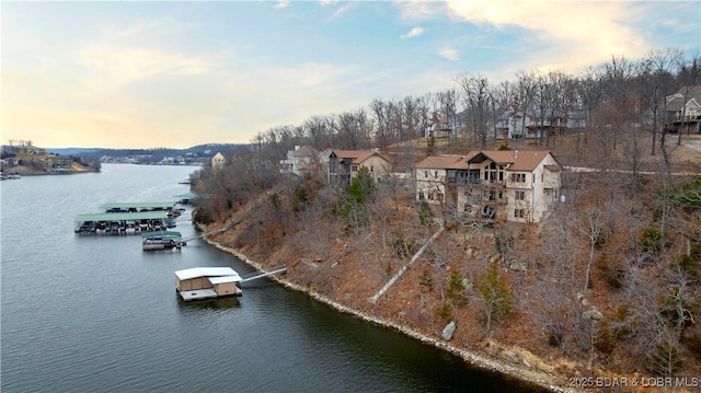 aerial view at dusk featuring a water view