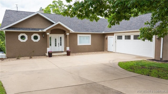 single story home featuring a shingled roof, concrete driveway, and stucco siding