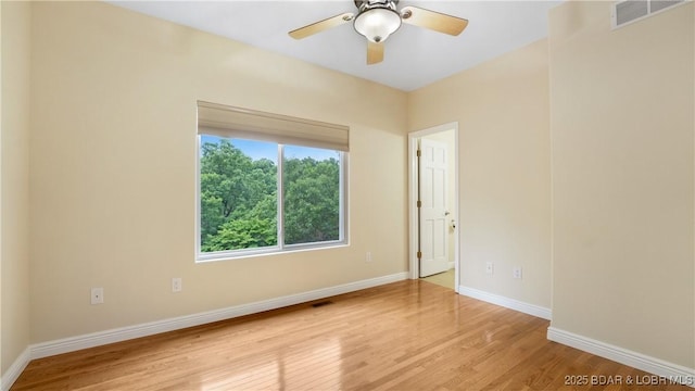 spare room with light wood-style floors, visible vents, ceiling fan, and baseboards