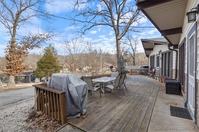 wooden deck featuring grilling area and outdoor dining area