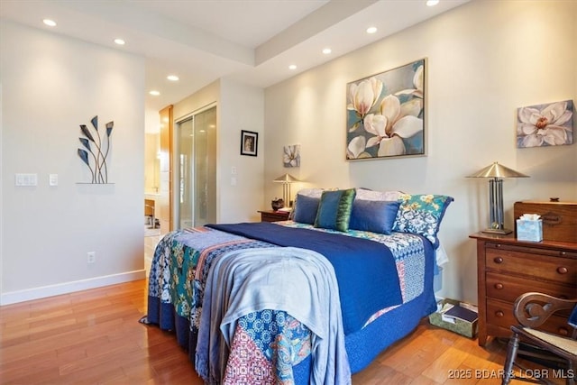 bedroom featuring recessed lighting, wood finished floors, baseboards, a closet, and ensuite bath