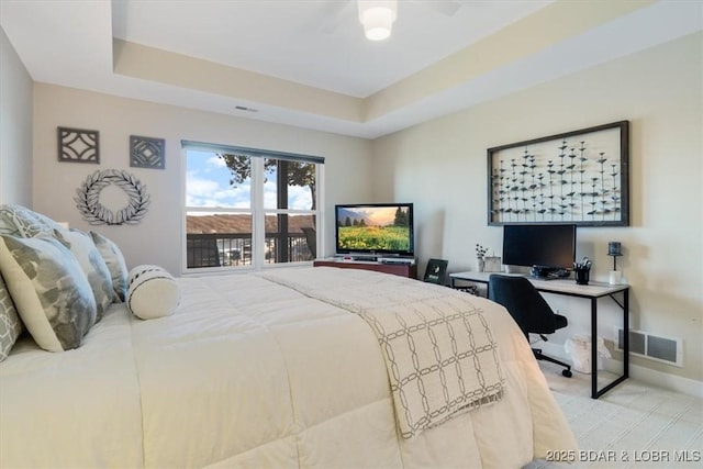 bedroom with baseboards, visible vents, and a raised ceiling