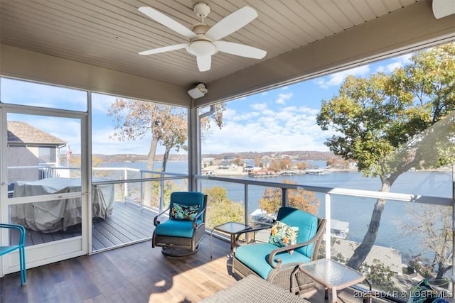 unfurnished sunroom featuring a water view and ceiling fan