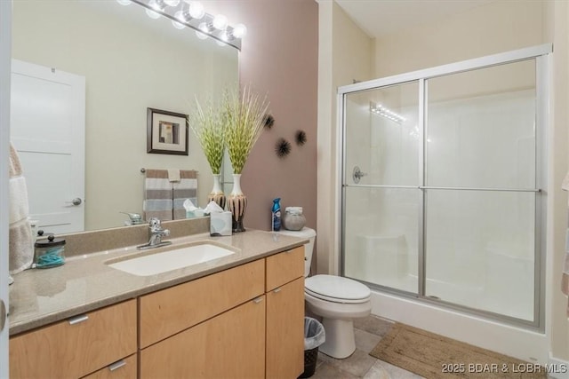 bathroom featuring a stall shower, tile patterned flooring, vanity, and toilet