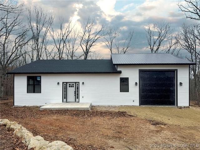 ranch-style home featuring a garage, a patio area, and driveway