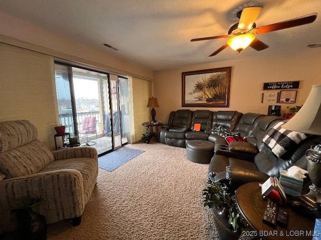 living room with carpet, visible vents, ceiling fan, and a textured ceiling