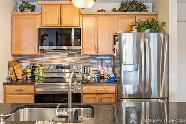 kitchen featuring dark stone countertops, appliances with stainless steel finishes, and backsplash