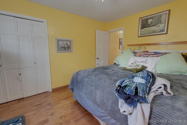 bedroom featuring a closet, light wood-style flooring, and baseboards