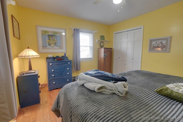 bedroom featuring light wood-style floors, a ceiling fan, and a closet