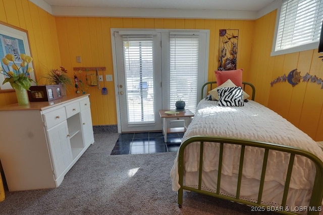 bedroom featuring access to outside, dark tile patterned floors, and dark colored carpet