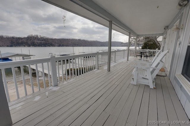 deck with a forest view and a water view